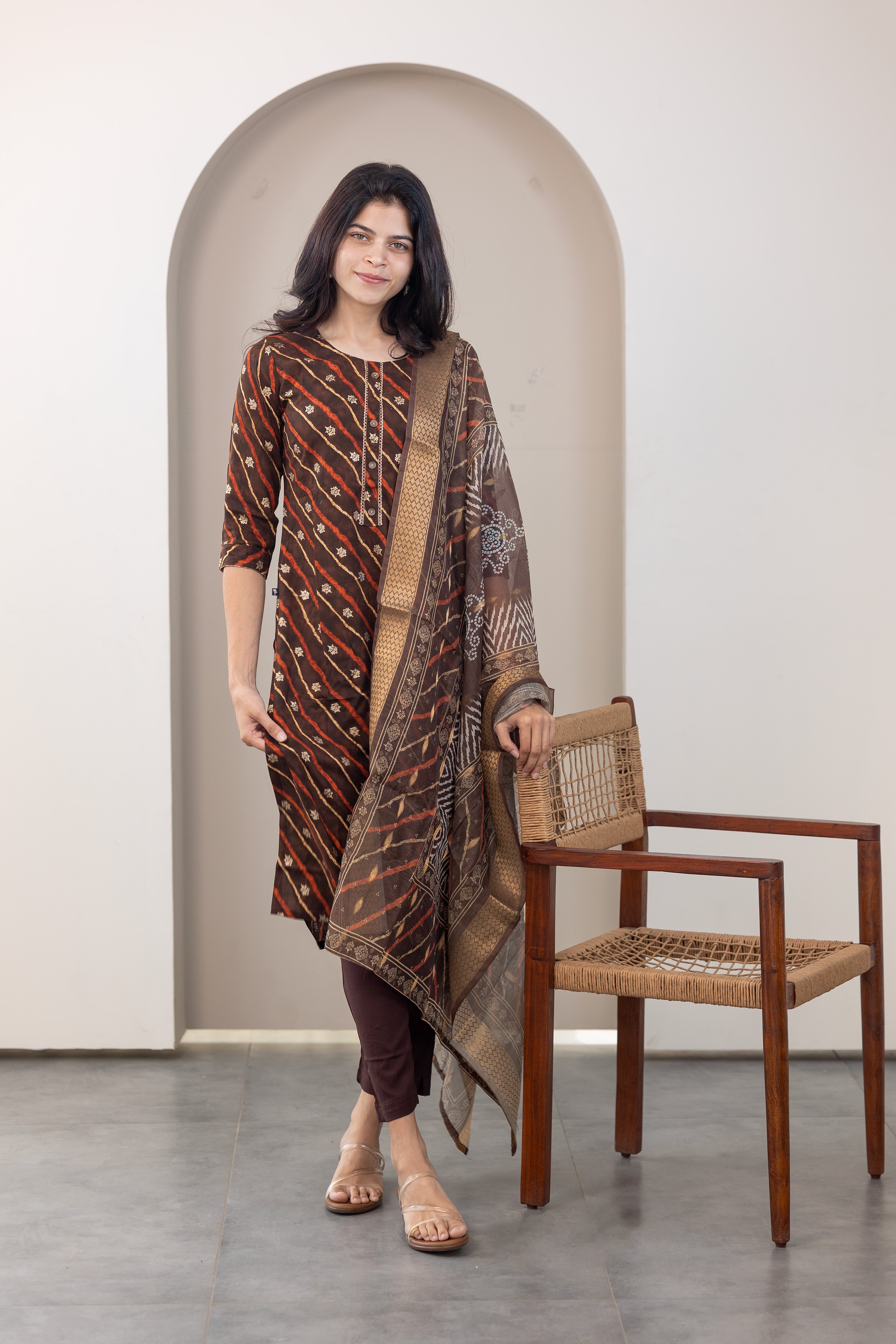 Poonguzhali salwar set in dark brown with gold printed design