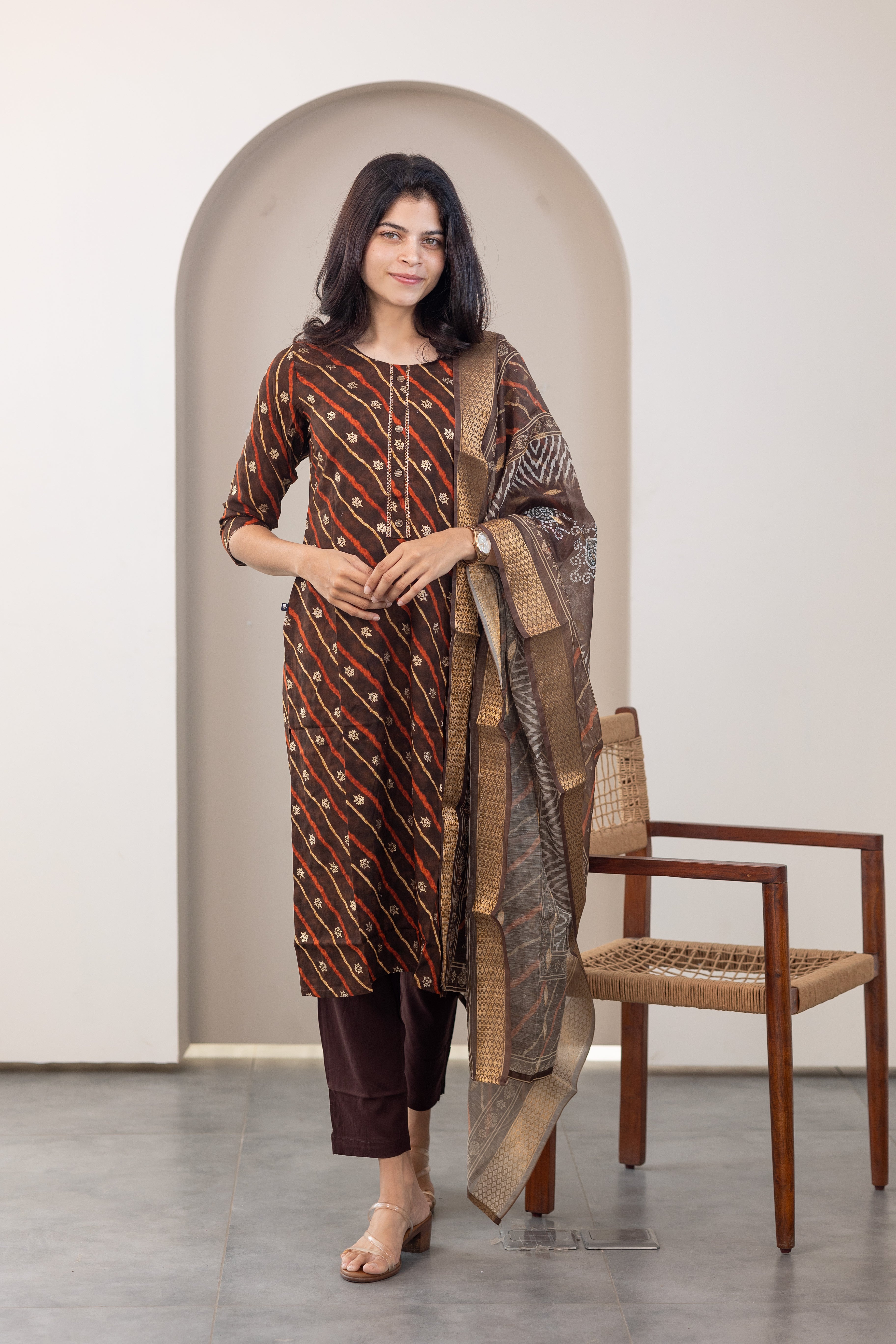 Poonguzhali salwar set in dark brown with gold printed design