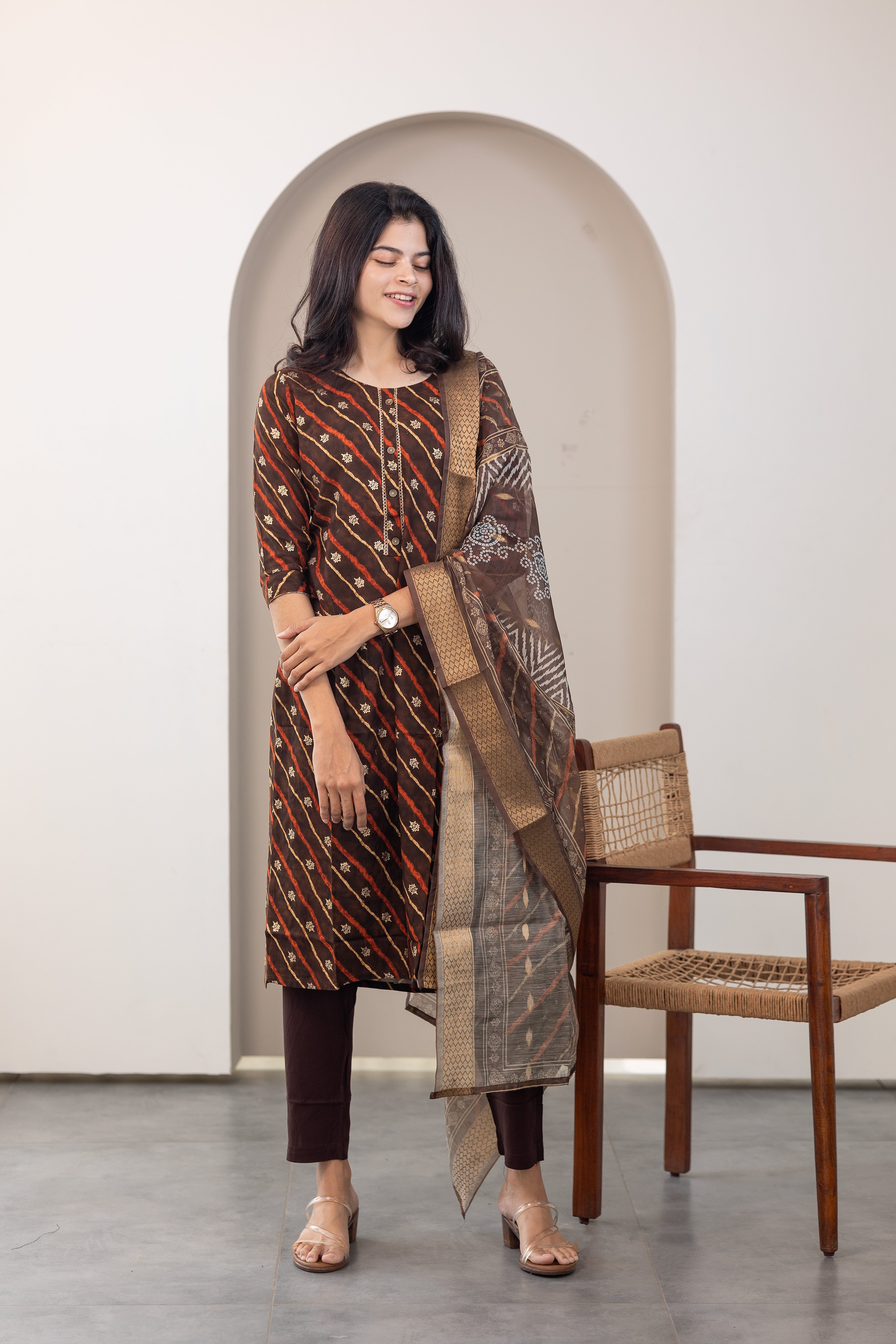 Poonguzhali salwar set in dark brown with gold printed design