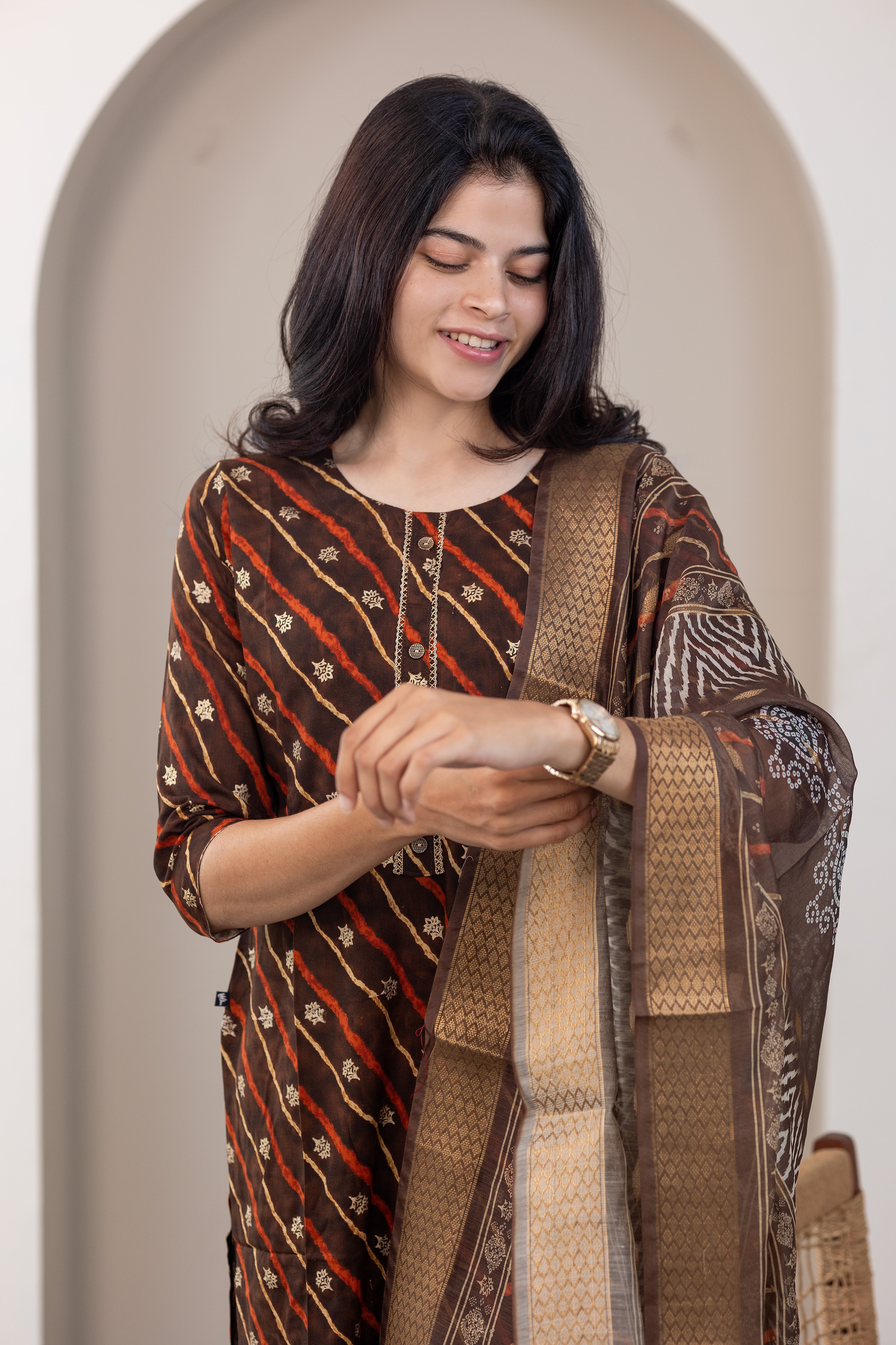 Poonguzhali salwar set in dark brown with gold printed design