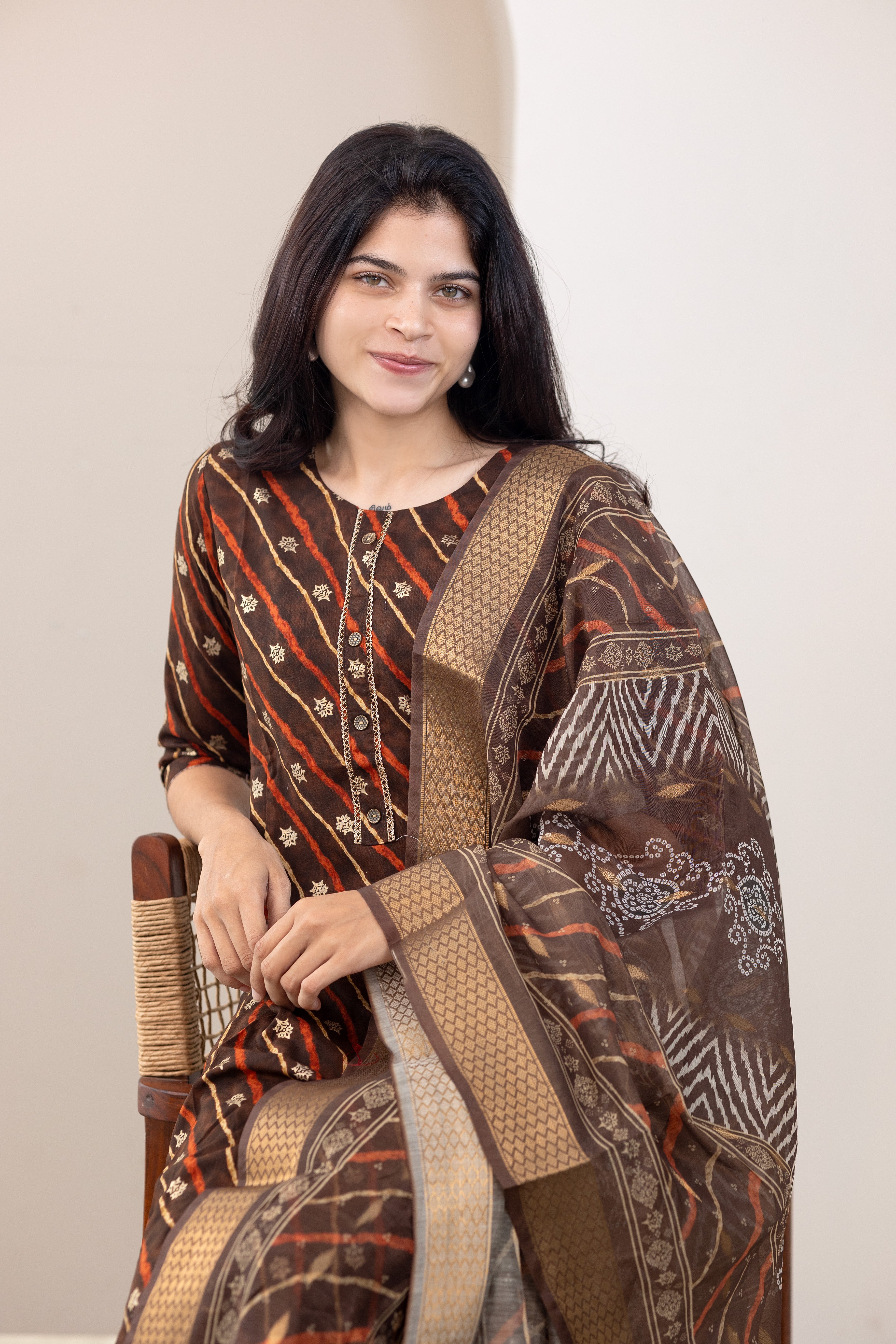 Poonguzhali salwar set in dark brown with gold printed design