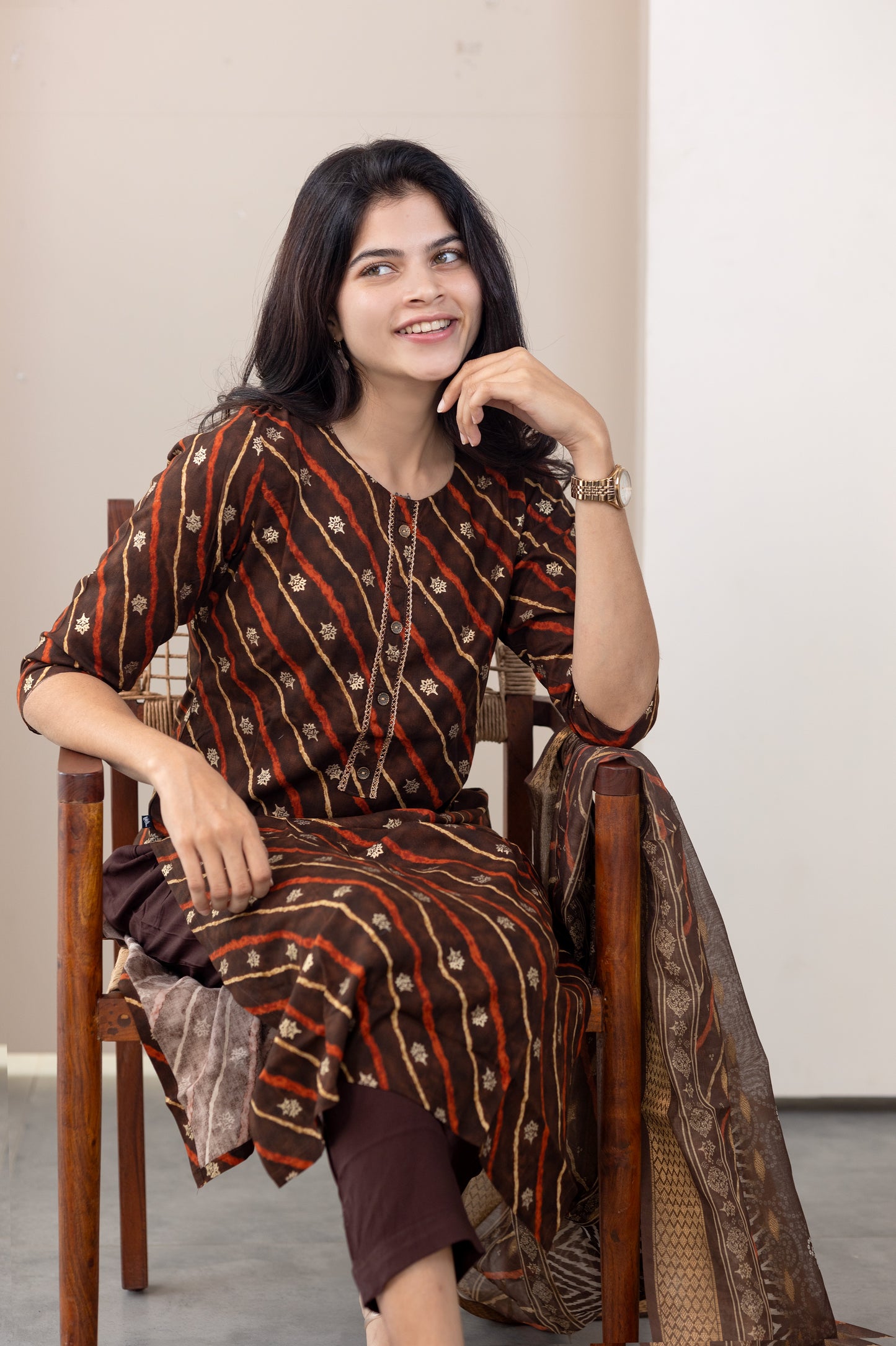 Poonguzhali salwar set in dark brown with gold printed design